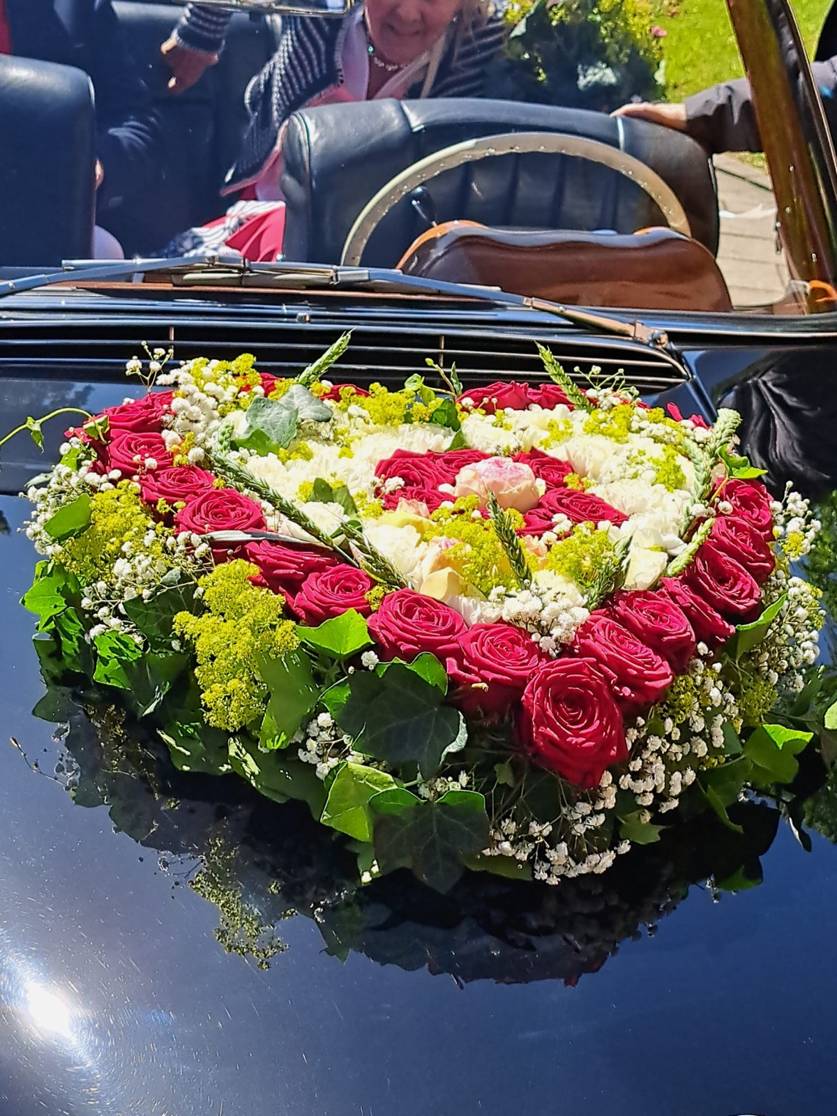 Autoschmuck zur Hochzeit: Herz aus roten Rosen auf der Motorhaube des Oldtimers