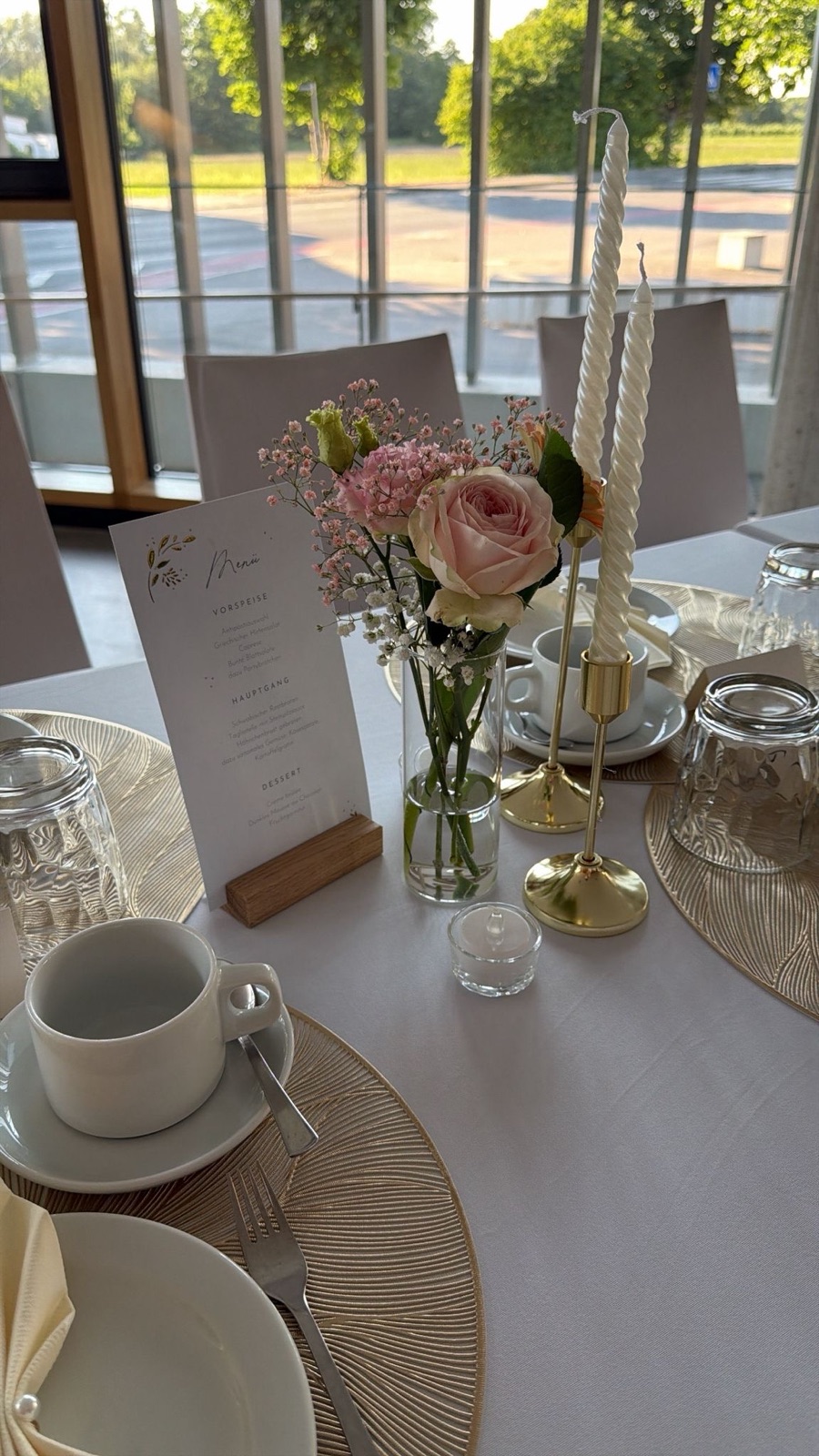 Tischdekoration mit Rosen, Schleierkraut und goldenen Kerzenhaltern – Eventfloristik am Bodensee