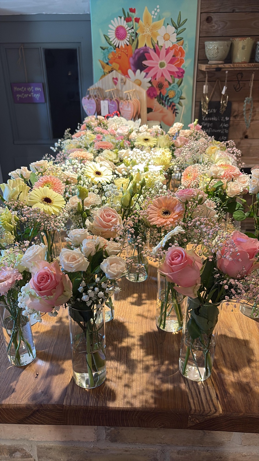 Kleine Vasen mit Rosen und Gerbera als Tischdekoration vorbereitet