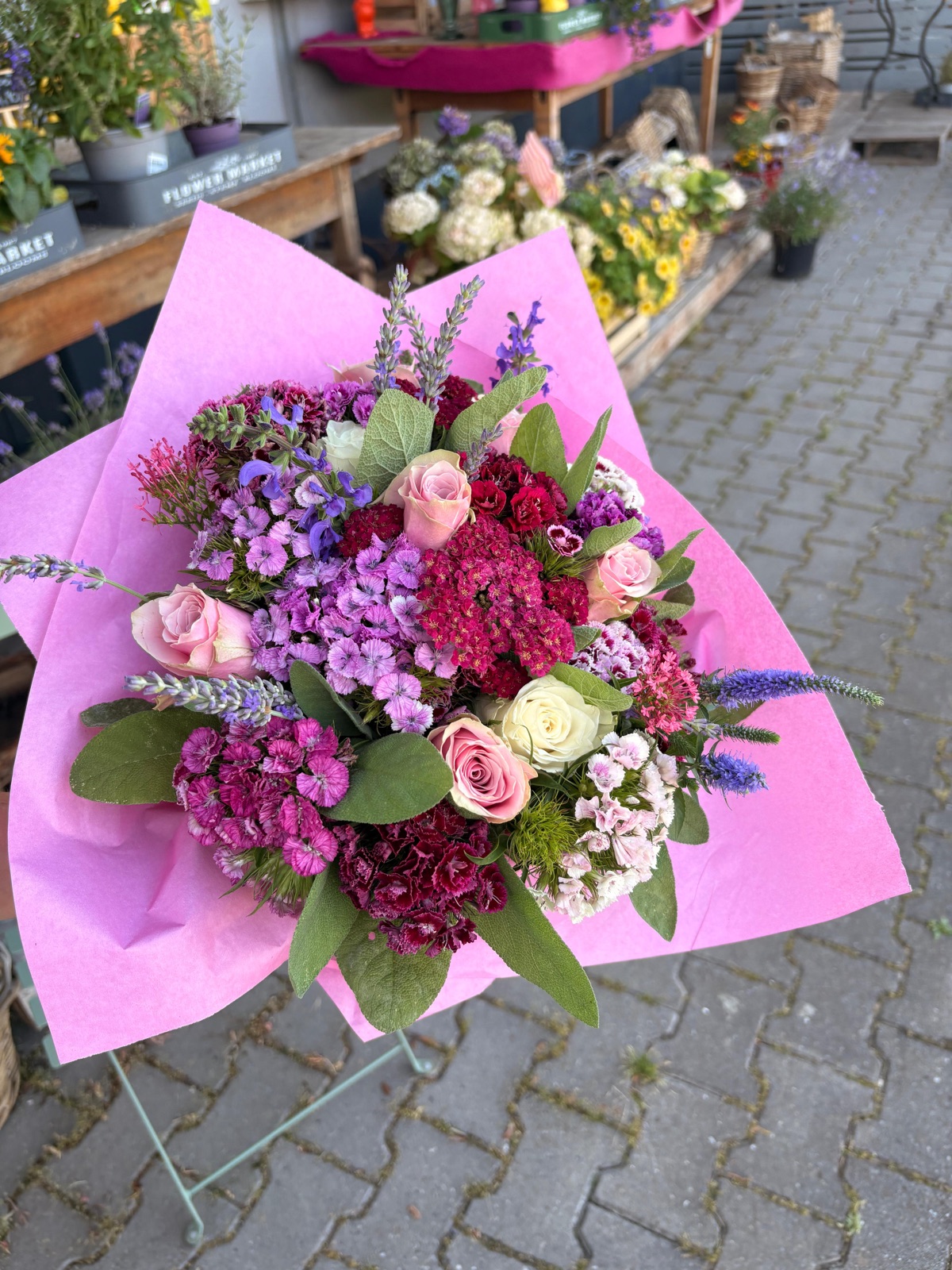 Üppiger Sommerstrauß mit Bartnelken, Rosen und Lavendel in rosa Papier