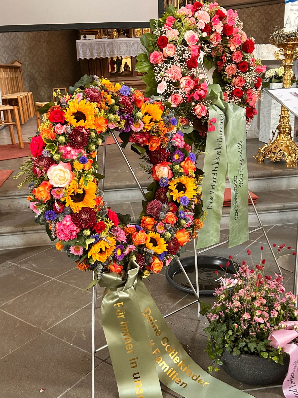 Zwei Trauerkränze mit Schleifen in der Kirche